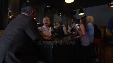 Hizmet ve meşgul bir şık barda genç çiftle sohbet barmen.