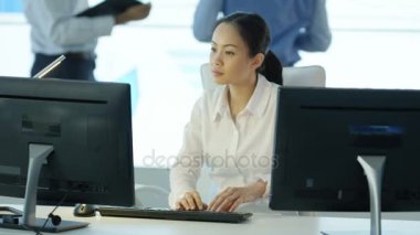 4k portre gülümseyen işkadını masasında arka planda meslektaşları ile çalışma