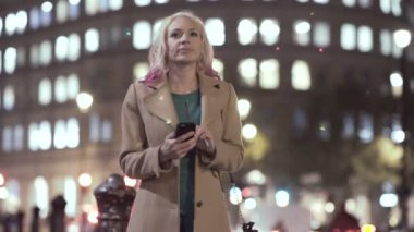 Smartphone vasıl seyir ve bir taksi şehrin aşağı işaretleme 4 k genç kadın