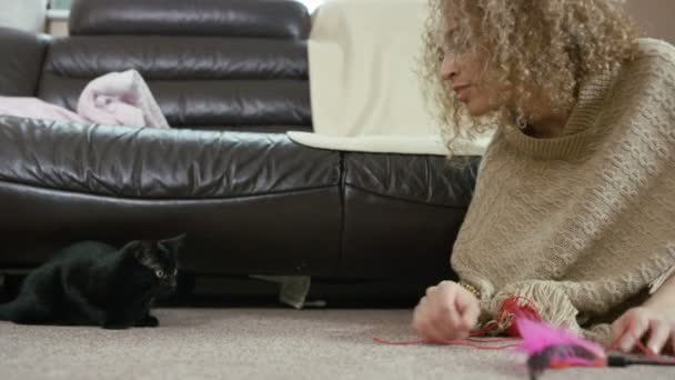 Νεαρή Γυναίκα Παίζει Χαριτωμένο Μαύρο Γατάκι Στο Σπίτι — Αρχείο Βίντεο