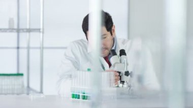 mikroskop altında örnek bakarak laboratuvarda çalışan 4 k araştırma bilim adamı.