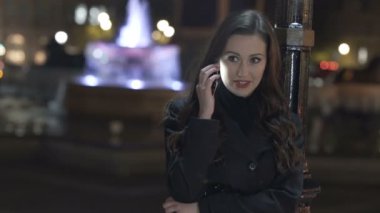 4k açık havada şehirde telefonda konuşmak güzel gülümseyen kadın portresi.