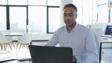 Şirket ofisi içinde laptop üzerinde ciddi Asya işadamı portresi