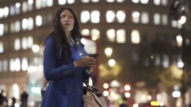 Smartphone vasıl arıyorsunuz ve gece şehirde taksi almaya çalışırken 4 k genç kadın