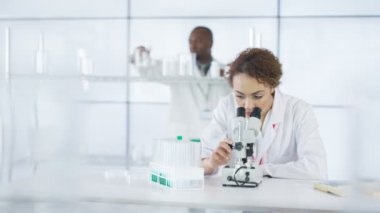 mikroskop altında örnek bakarak laboratuvarda çalışan 4 k araştırma bilim adamı.