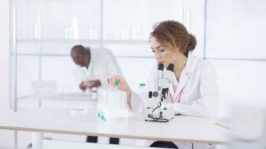mikroskop altında örnek bakarak laboratuvarda çalışan 4 k araştırma bilim adamı.