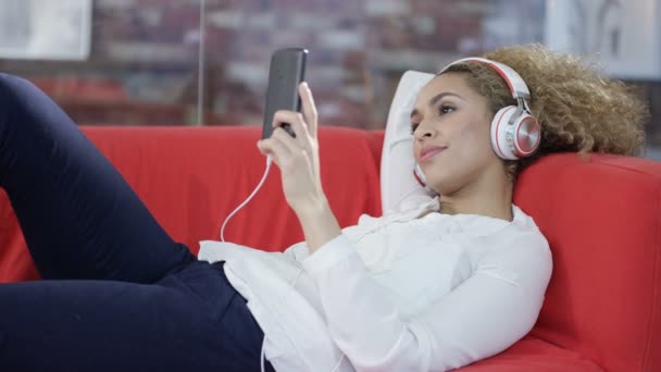 有魅力的妇女在家放松 听音乐与耳机和智能手机 — 图库视频影像