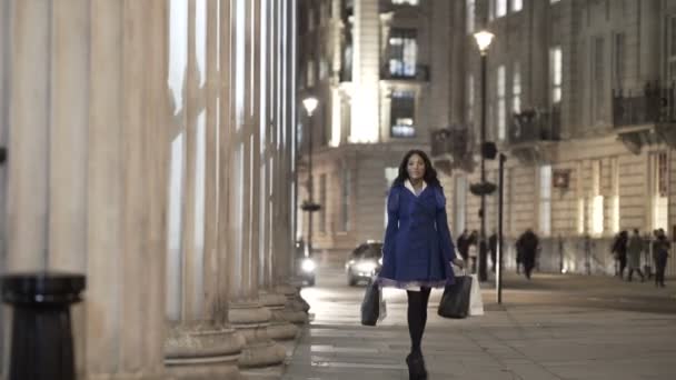 夜市で買い物袋と歩いている肖像画美しい笑みを浮かべて少女 — ストック動画
