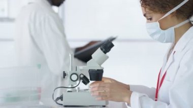 mikroskop altında örnek bakarak laboratuvarda çalışan 4 k araştırma bilim adamı.