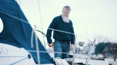 4k olgun sakallı adam Marinada, demirledi tekne ile bir yelken gezisi için hazırlanıyor
