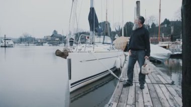 4k gülümseyen portresi sakallı adam yelkenli tekne bir Marina önünde ayakta