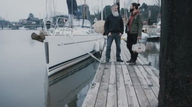 4k gülümseyen portresi sakallı erkekler yelkenli tekne bir Marina önünde duran