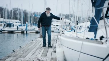 4k olgun sakallı adam Marinada, demirledi tekne ile bir yelken gezisi için hazırlanıyor