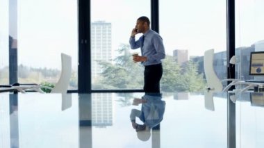 4 k neşeli işadamı telefon ofisinde pencerenin önünde konuşurken.