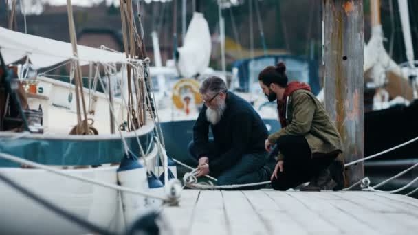 の父と息子の桟橋で彼らのボートを係留しながらチャット — ストック動画
