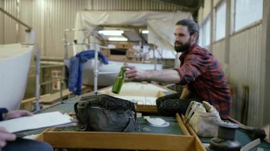 4k bir mola ve bir bira olan tekne inşaat işinde çalışan iki adam.