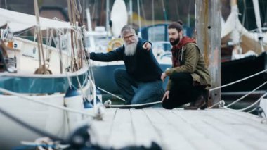 4 k baba ve oğul iskelede kendi tekne bağlama sırasında sohbet