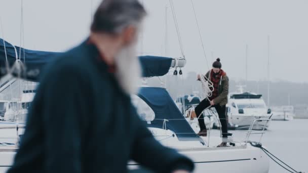 Volwassen Man Coiling Touw Een Jacht Aangemeerd Een Jachthaven Praten — Stockvideo