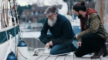 4 k baba ve oğul iskelede kendi tekne bağlama sırasında sohbet