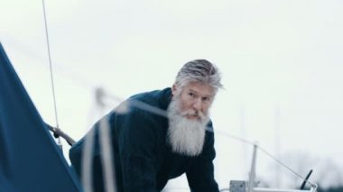 4k olgun sakallı adam Marinada, demirledi tekne ile bir yelken gezisi için hazırlanıyor