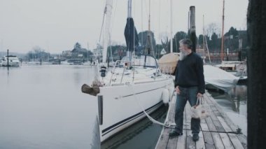 4 k portre od gülümseyen adam yelkenli tekne bir Marina önünde ayakta sakallı.