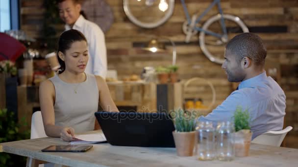 ビジネスの男性と女性のカフェでミーティングを持つウェイトレス ドリンク — ストック動画
