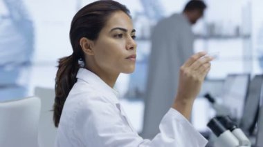 mikroskop altında bir slayt bakarak ve bilgisayarda çalışan 4 k tıp araştırmacısı