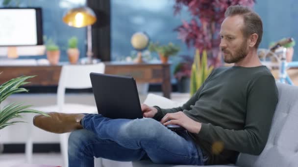 Casual Homem Relaxante Casa Usando Smartphone Laptop Seguida Tirar Uma — Vídeo de Stock