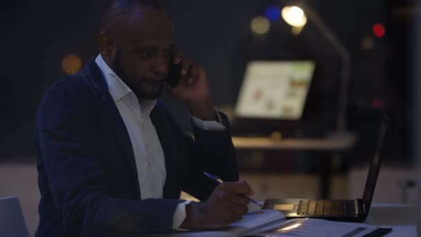 Обеспокоенный Бизнесмен Работающий Допоздна Просматривая Цифры Разговаривая Телефону — стоковое видео