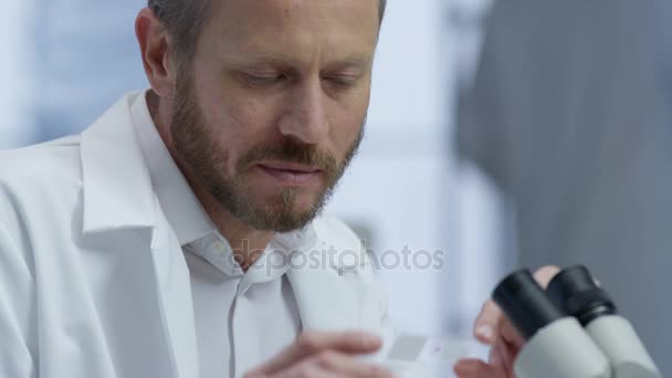 Close Pesquisador Médico Laboratório Olhando Para Uma Corrediça Sob Microscópio — Vídeo de Stock