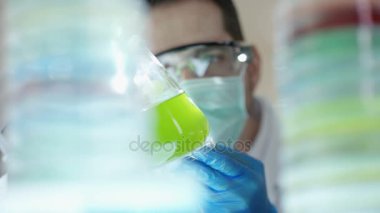 Laboratuvarda renkli sıvılarla çalışan kimya araştırmacısı..