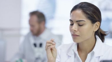 tıbbi araştırmacı laboratuarda mikroskop altında bir slayt bakarak 4k yakın çekim