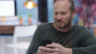 evde manifatura rahatlatıcı veya Internet üzerinde onun smartphone kullanarak 4 k mutlu adam