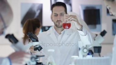 Bilimsel araştırma ekibi laboratuarında, kimyasallar ile deneme adam odaklanmak çalışıyor.