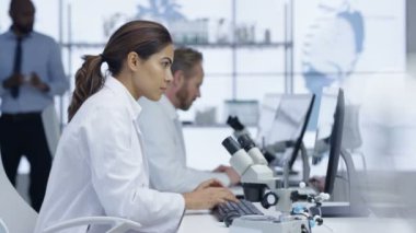 4 k tıp araştırmacısı laboratuvardaki bilgisayarda çalışarak ve mikroskop arıyorum
