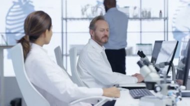 bilgisayarlarda çalışma ve işlerini tartışan 4 k tıbbi araştırmacılar laboratuarında.