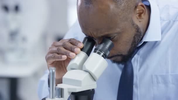 Close Pesquisador Médico Laboratório Olhando Para Uma Corrediça Sob Microscópio — Vídeo de Stock