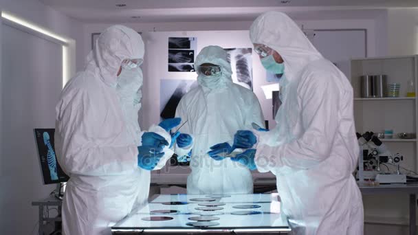 在无菌实验室中穿着全身衣对高科技材料进行检测的科研队伍 — 图库视频影像