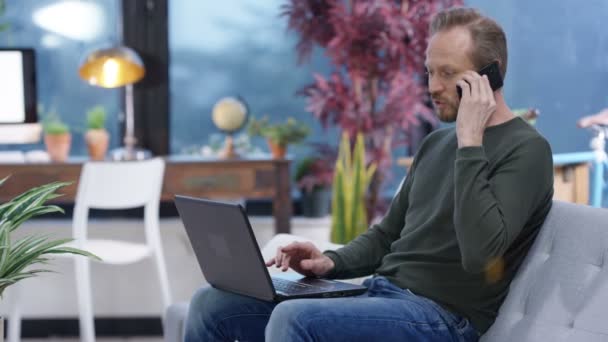 Veselým Příležitostné Muž Pracující Domova Pracovat Notebooku Mluví Telefonu — Stock video
