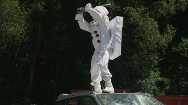 車の上に立って 野球のバットで車を壊して 積極的なの宇宙飛行士 — ストック動画