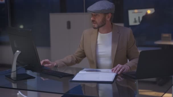 工作到深夜的商人查看计算机和文件的财务细节 — 图库视频影像