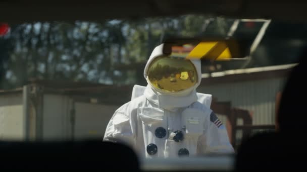 野球のバットを振る車の屋根の上に登って 積極的な宇宙飛行士 — ストック動画
