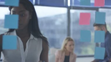 Birlikte, yapışkan notlar ile beyin fırtınası genç kadın çalışan yaratıcı iş takım.