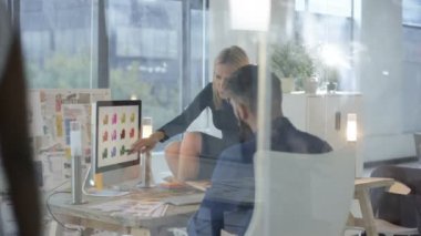 Bir proje üzerinde işbirliği tasarımcıları yaratıcı ofiste bilgisayar üzerinde çalışan.