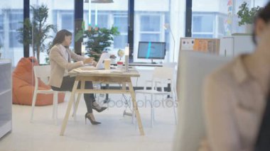 4k dizüstü bilgisayarda çalışan ve Office telefonda konuşurken kadın iş Yöneticisi meşgul