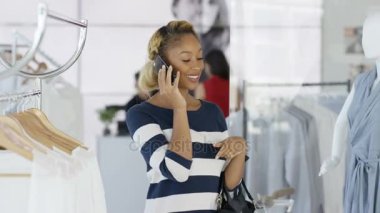 Güzel kadın telefonu o butik giyim mağazasında alışveriş sırasında söz.
