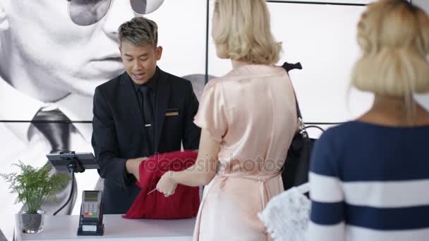 Жінка Купує Магазині Одягу Роблячи Оплату Кредитною Карткою Інші Клієнти — стокове відео