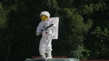 araba üzerinde duran ve araba bir beysbol sopası ile smashing 4 k agresif astronot.