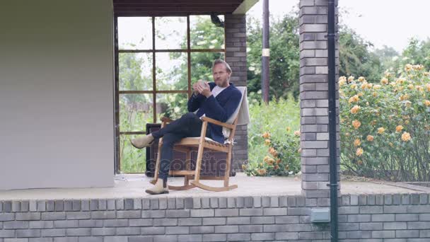Homme Relaxant Extérieur Assis Sur Porche Regardant Vue — Video