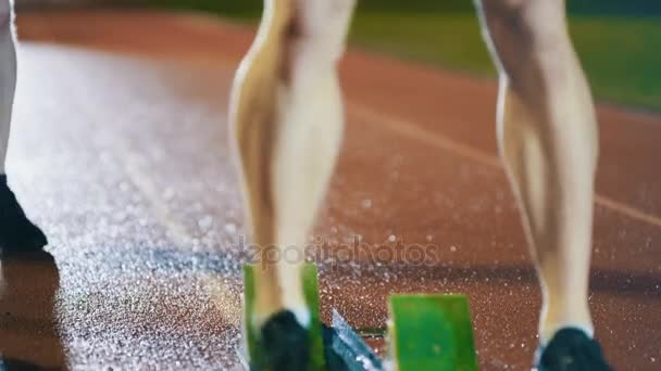 Mężczyzna Biegaczy Lekkoatletyce Śledzić Przyczajony Bloki Startowe Przed Wyścigiem — Wideo stockowe
